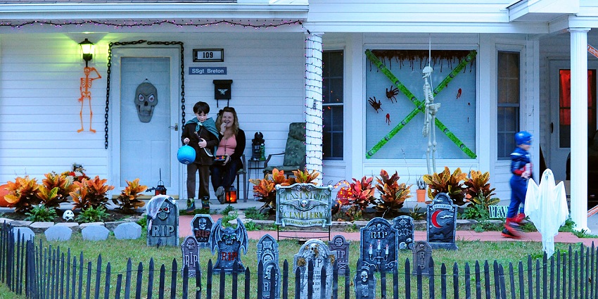 A boy looks at the artificial cemetery posts kept in front of his house during Halloween, similar to what's expected in Halloween day 2025.