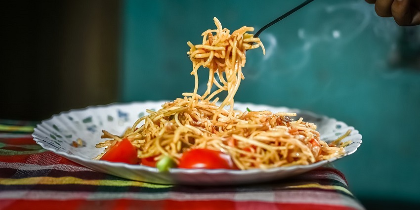 A heap of chowmein noodles, richly coated with the spicy sauce, capsicum, and spices.
