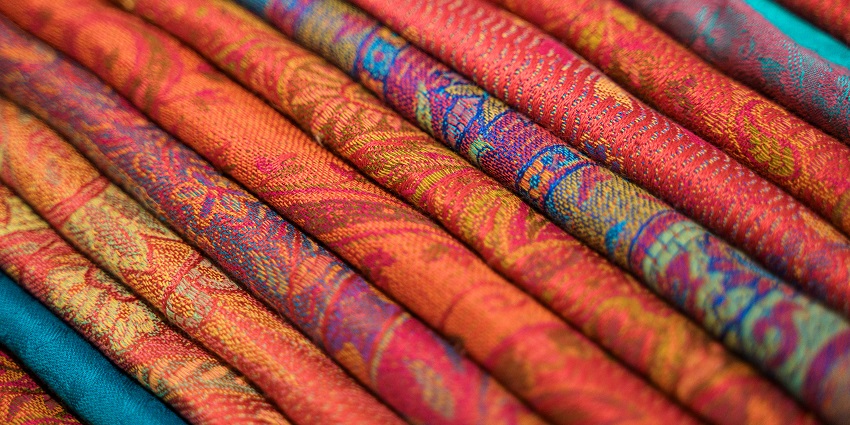 Close-up of stacked pashmina shawls at the Himalayan Pashmina Shawl Shop, shopping in Ladakh.
