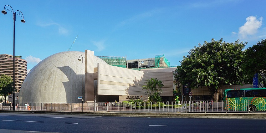 Hong Kong Space Museum, with a white dome structure beside trees anda clear sky, one of the iconic museums in Hong Kong.