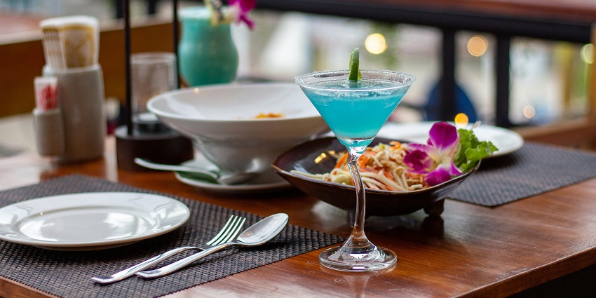 Blue cocktail and flower-topped salad at Hotel Bhansa Ghar, a homely spot among restaurants in Pelling.
