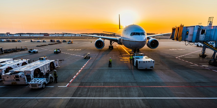 Jaipur International Airport with an airplane on the runway during sunset.