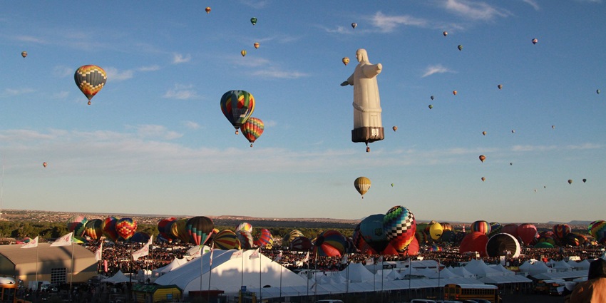 Several hot air balloons flying in the Albuquerque International Balloon Fiesta visible from the parking area.
