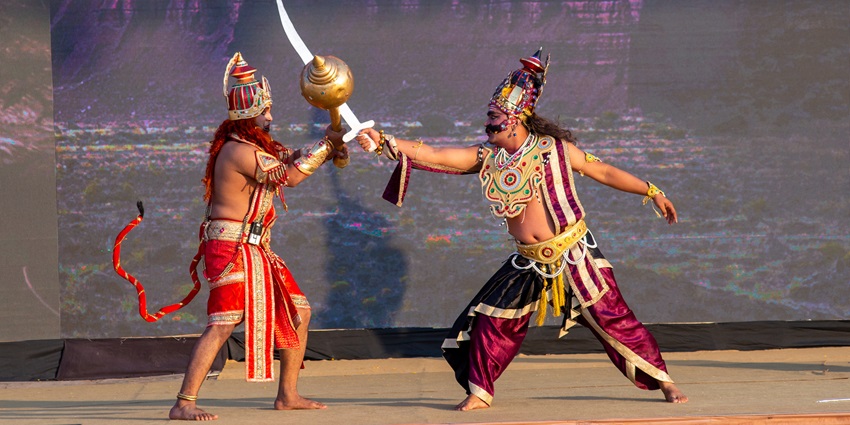 Artists in costumes perform a Ramayana scene on stage during Dussehra celebration event.