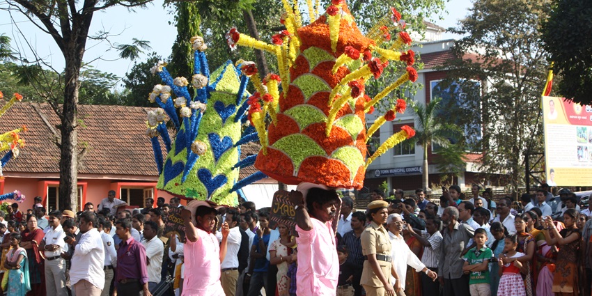 Two men carry a huge floral pyramid over their heads during the Karaga Festival in Karnataka.