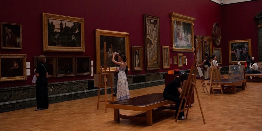 Visitors exploring the interior of Kashi Art Gallery with paintings on display, one of the top art galleries in Kerala.