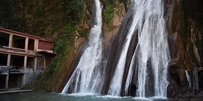 Kempty Falls cascading through rocky cliffs, a popular attraction among waterfalls in Uttarakhand.