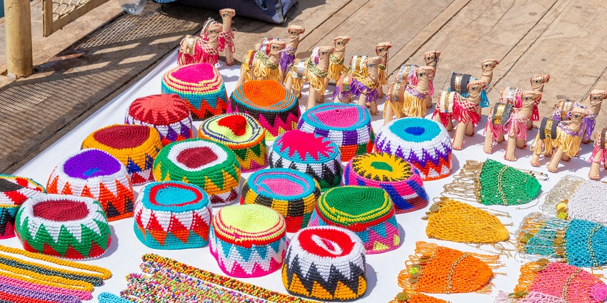 Colourful handicraft souvenirs are displayed on shelves at the Kerala Handicrafts Emporium.
