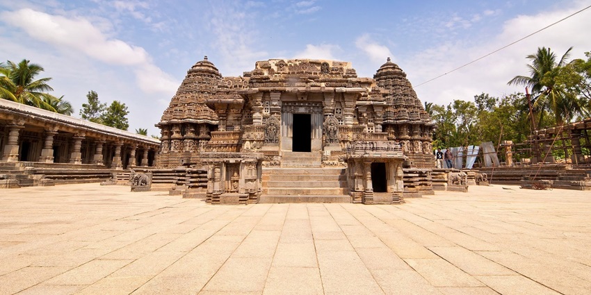 A wide shot of an ornate stone temple with multiple towers at temples in Karnataka.