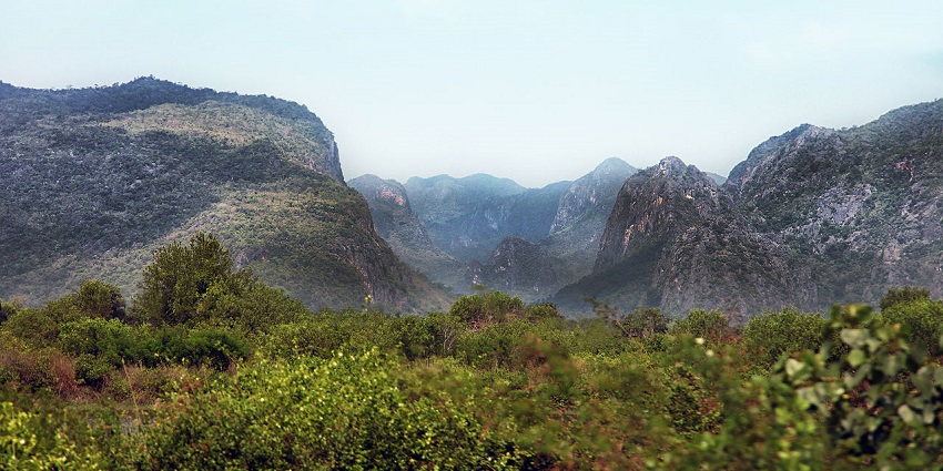 Limestone mountains and green valleys under clear sky at Khao Sam Roi Yot National Park.
