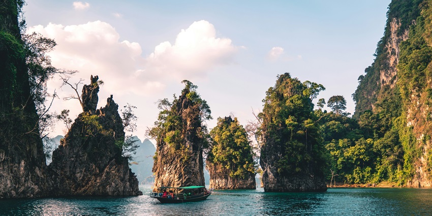 Limestone rock formations rising from water in Khao Sok, perfect for trekking in Thailand.