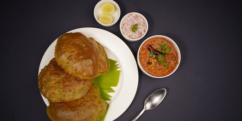 Hot and crispy chole bhature served with spicy chickpea curry at Khushboo restaurant.