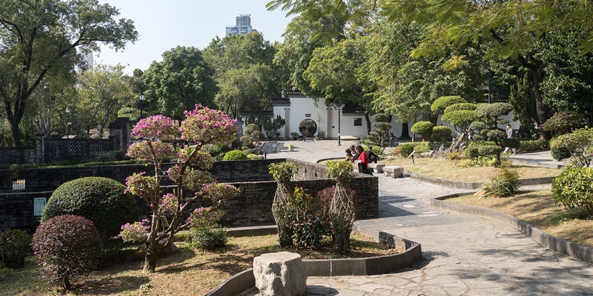 Pathways, plants, and historic-style structures inside Kowloon Walled City Park, Hong Kong.
