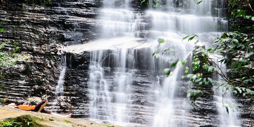 Waterfall flowing through lush greenery at Kubah National Park, one of the popular parks in Malaysia.
