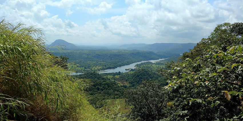 A high-angle view of a serene river winding through green hills, a spot for scuba diving in Karnataka.
