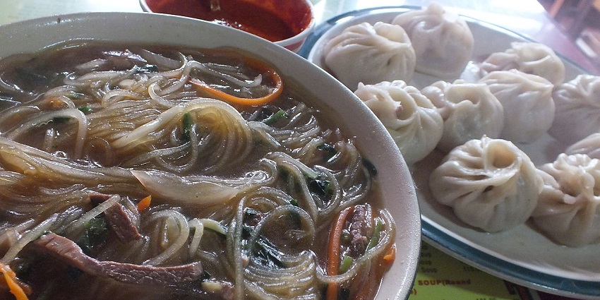 A plate of Tibetan momos and a bowl of thukpa, popular dishes at Kunga Restaurant in Darjeeling.
