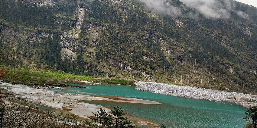 Lachung valley with a clean turquoise water body surrounded by mountains, one of the serene hill stations in Sikkim.
