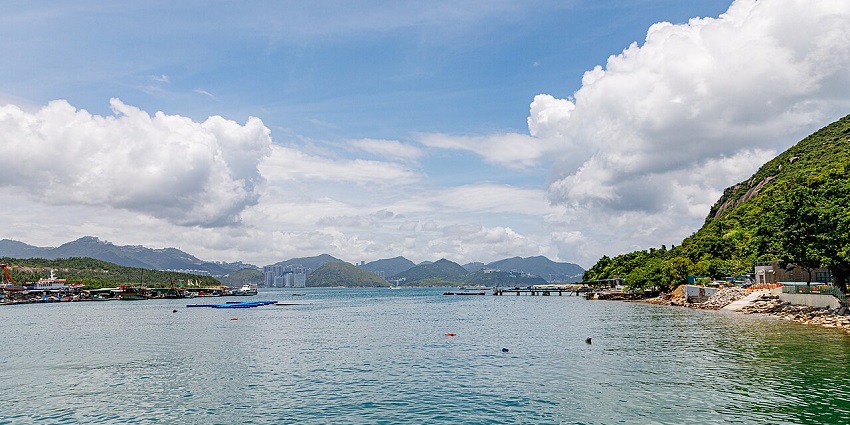 Lamma Island with a clear water body and small cliffs and mountains visible at a distance.