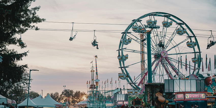 People enjoying amusement rides at Lavi Fair with lively crowd and festive atmosphere.
