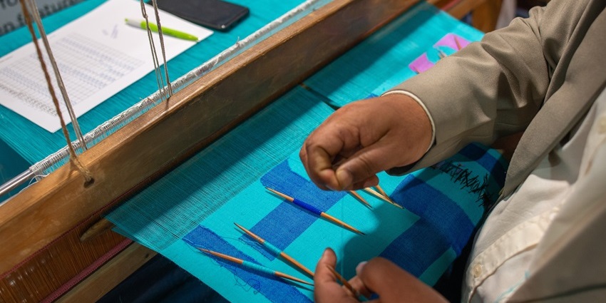 An artist's hand with thread and needle making traditional Kani shawl duringTrade Fair.
