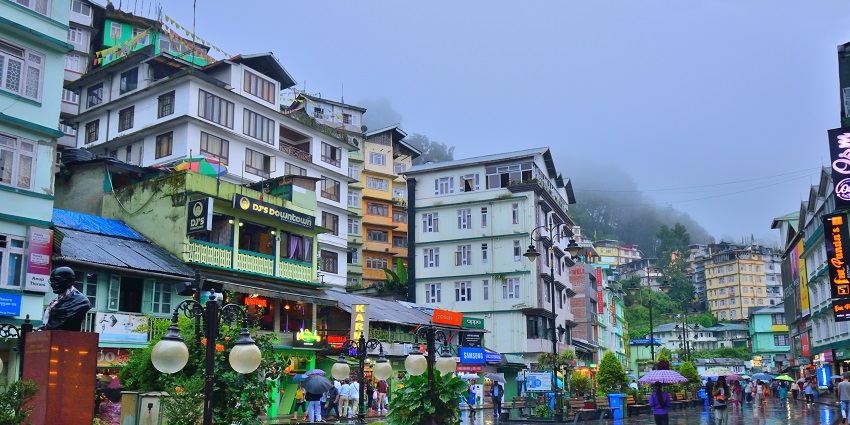 Daytime view of MG Marg in Gangtok with people walking and shops lining the street.