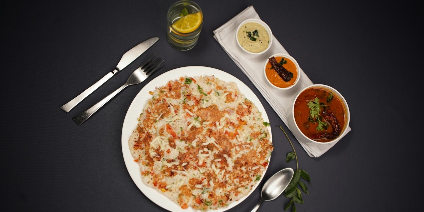 Onion uthappam served hot with chutneys at Madras New Woodlands restaurant.
