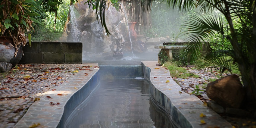 Steam rising from Mae Kachan Hot Spring with geysers and surrounding nature.