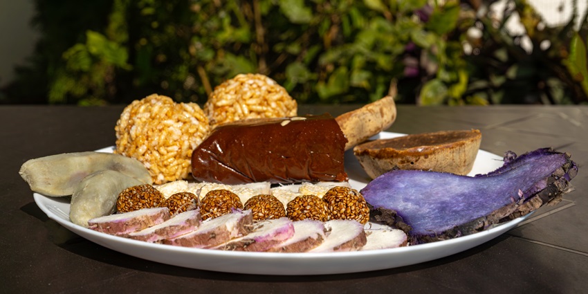 A festive plate with jaggery, sesame balls, yam, and sweet potato for Maghe Sankranti.