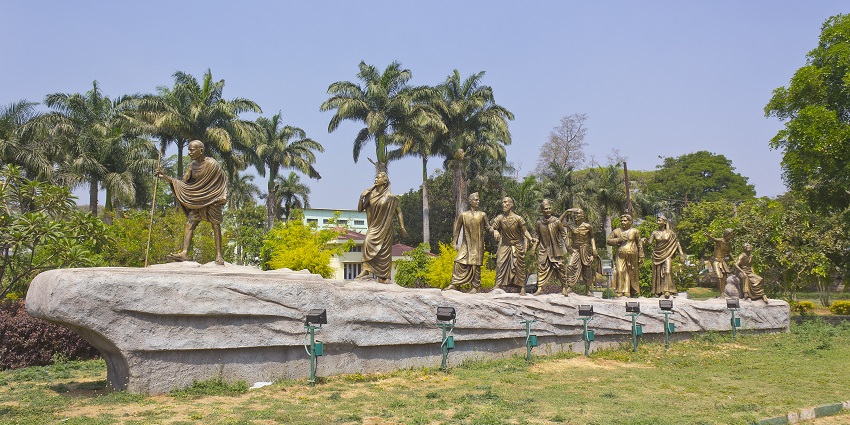 Mahatma Gandhi Park features green lawns, walking paths, and Gandhi monuments in a peaceful setting.
