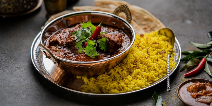Chicken curry with biryani served hot at Mairang Restaurant – a flavorful meal combo.