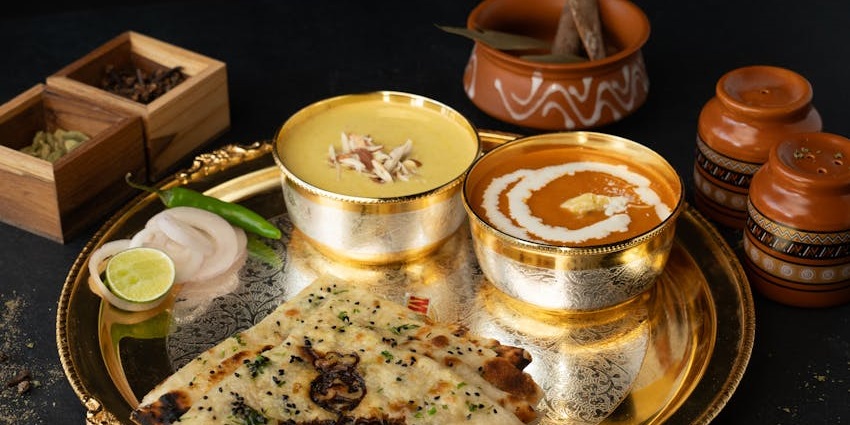 Indian thali with dal, naan, sabzi, and salad served at Makhan Bhog restaurant.