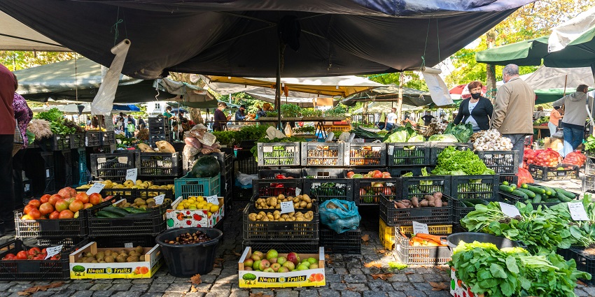 Malleswaram Market vegetable stalls are bustling with shoppers, showcasing shopping in Karnataka.
