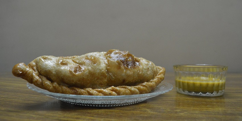 An Indian Shapale with spicy green chilly chutney, which has garlic, onions, and cabbage.
