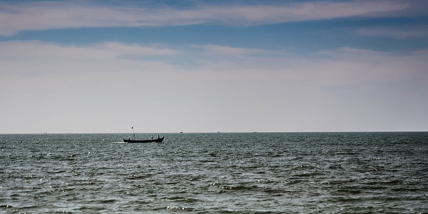 A vast view of Maravanthe Beach with endless blue waters merging into the horizon.
