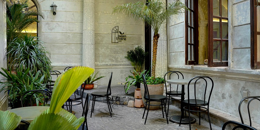 Cosy outdoor restaurant with windows, tables, chairs, and plants — one of the popular restaurants in Chinatown.
