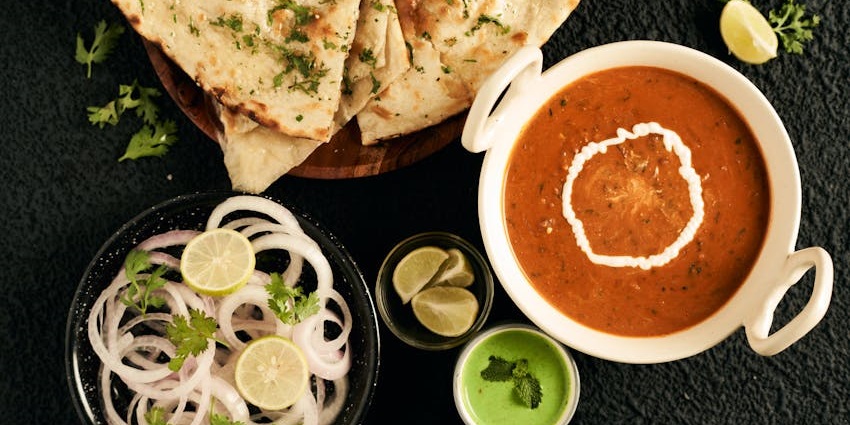 Top view of an Indian dish with onions and flatbread served at Monalisa Restaurant.