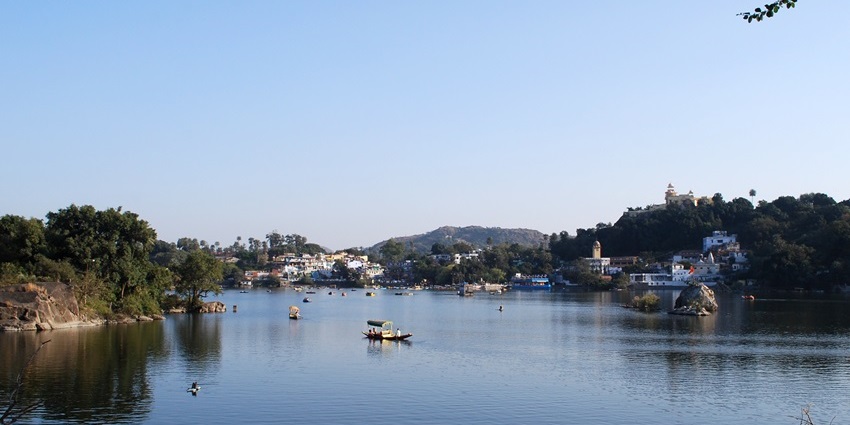 Scenic lake surrounded by Aravalli hills with pedal boats during New Year in Rajasthan.