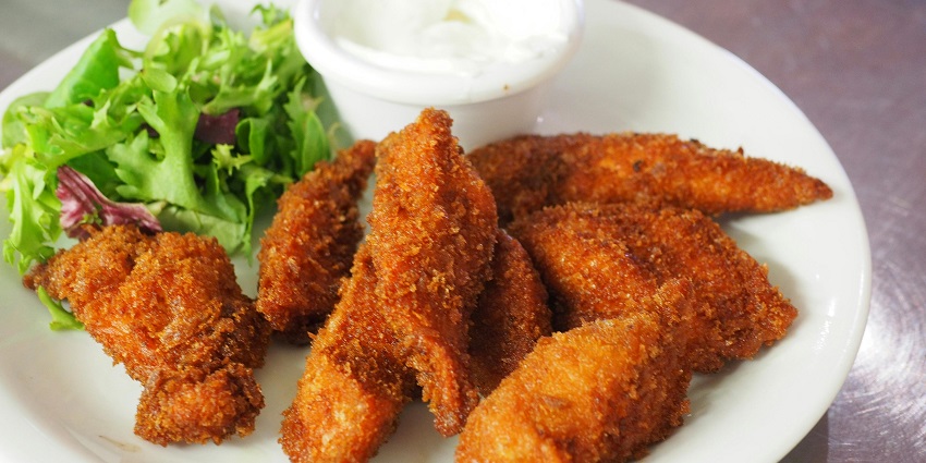 Fried chicken salad with dipping sauce served at Mu Kimchi on a plate.
