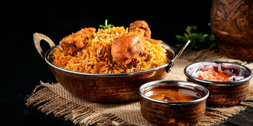 A plate of chicken biryani served with a side of chutney at Mumtaz Mahal Indian Restaurant.
