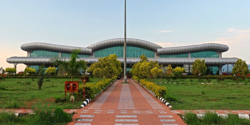 Front view of Mysore Airport terminal with landscaped garden and walkway leading inside, one of the top airports in Karnataka.