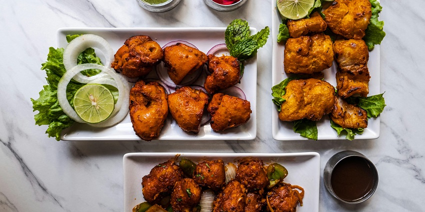 Chicken platter served with sauces and sides on a restaurant table.
