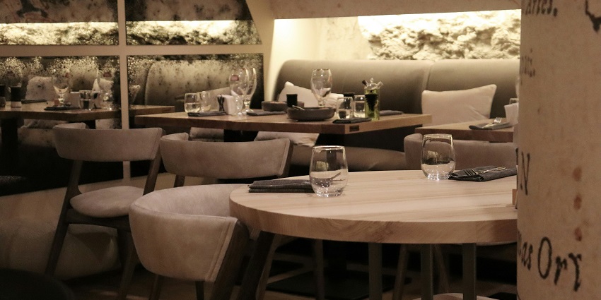 Namkha Restaurant interior with tables, chairs, and carved wall decorations.
