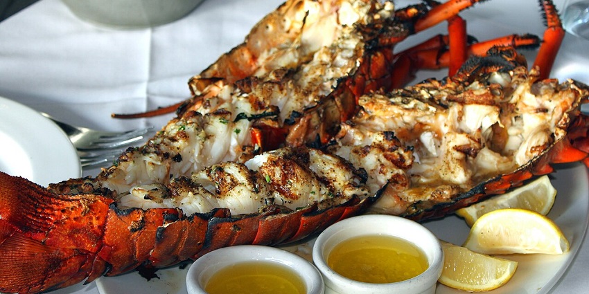 Freshly cooked grilled lobsters served with lemon slices at one of the top restaurants in Andaman.