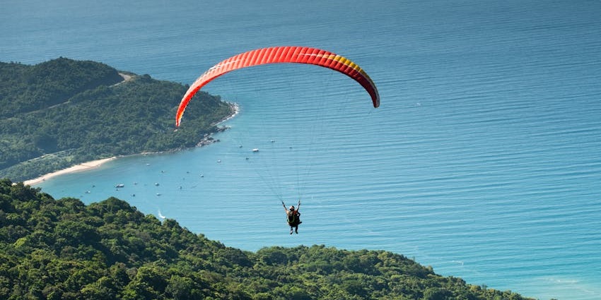 Paragliding in Andaman over North Bay Island with clear waters and lush green forests below.