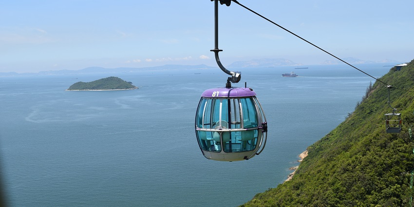 Single cable car gliding over lush greenery at Ocean Park, Hong Kong.