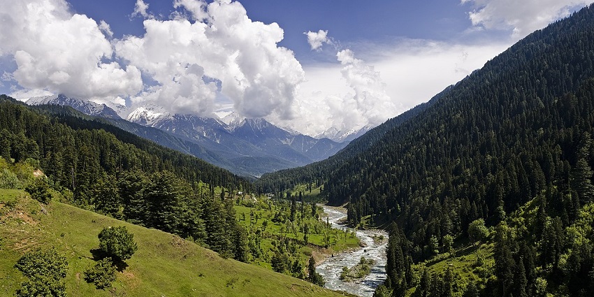 Chunks of fluffy clouds hover above the lush green hills of Pahalgam, one of the scenic valleys in Kashmir.