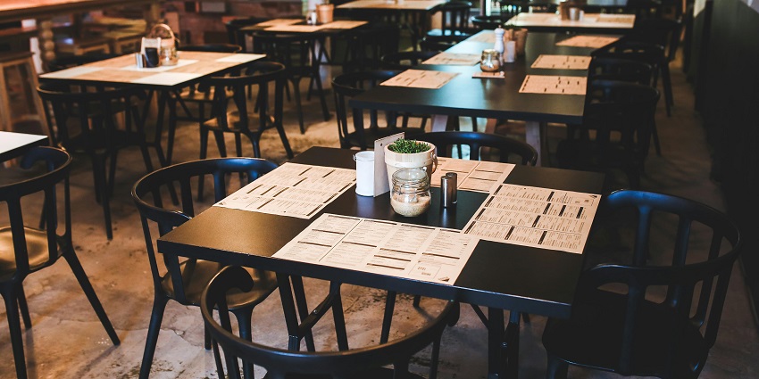 Modern restaurant with black tables, menus, and a bar, one of the top restaurants in Guwahati
