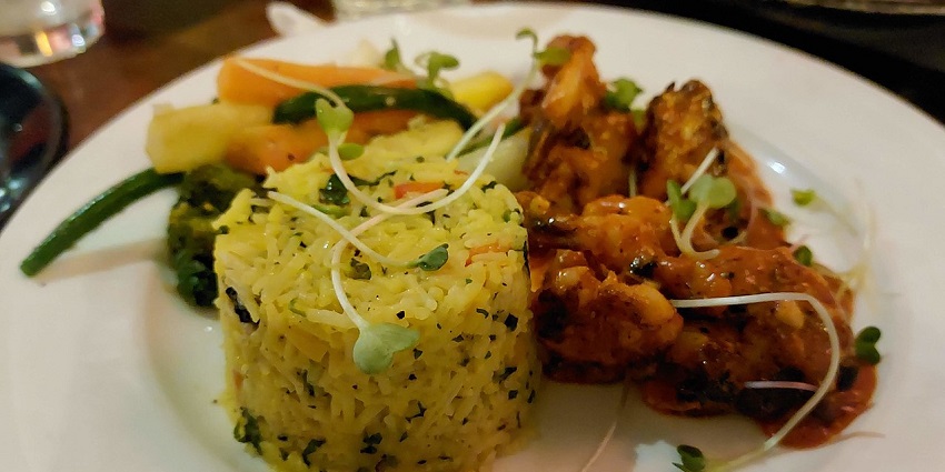 Plate with yellow rice, curry chicken & vegetables served at Pasha Food Centre in Antalya.