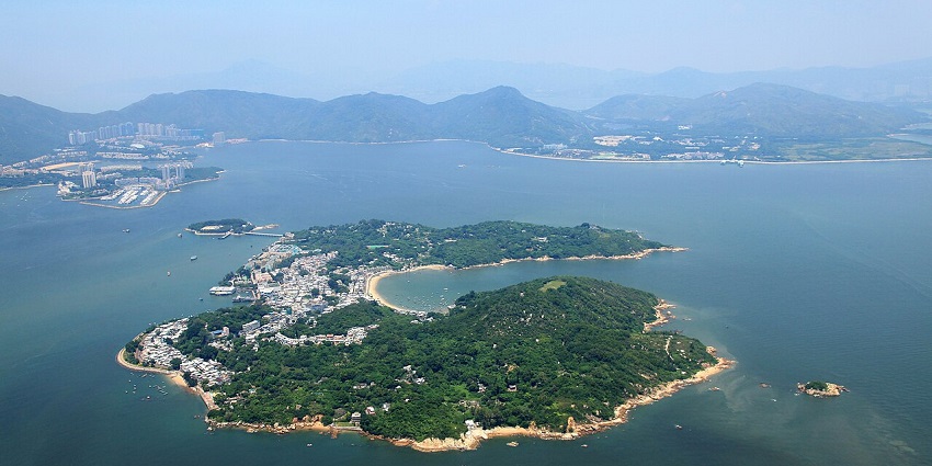 Aerial view of Peng Chau with small buildings and nearby towns in islands in Hong Kong.