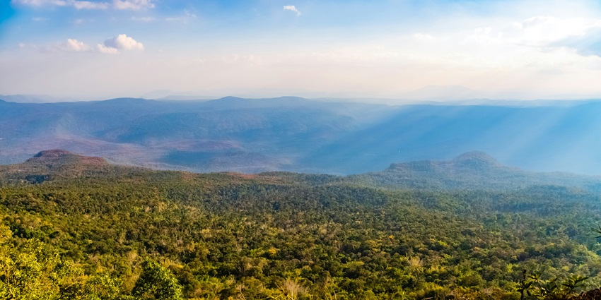 Sunset light casting golden rays over mountain peaks at Phu Kradueng National Park.